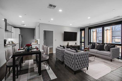 a living room with grey and white furniture and a table with chairs at Nineteen North Apartments , Buffalo, NY
